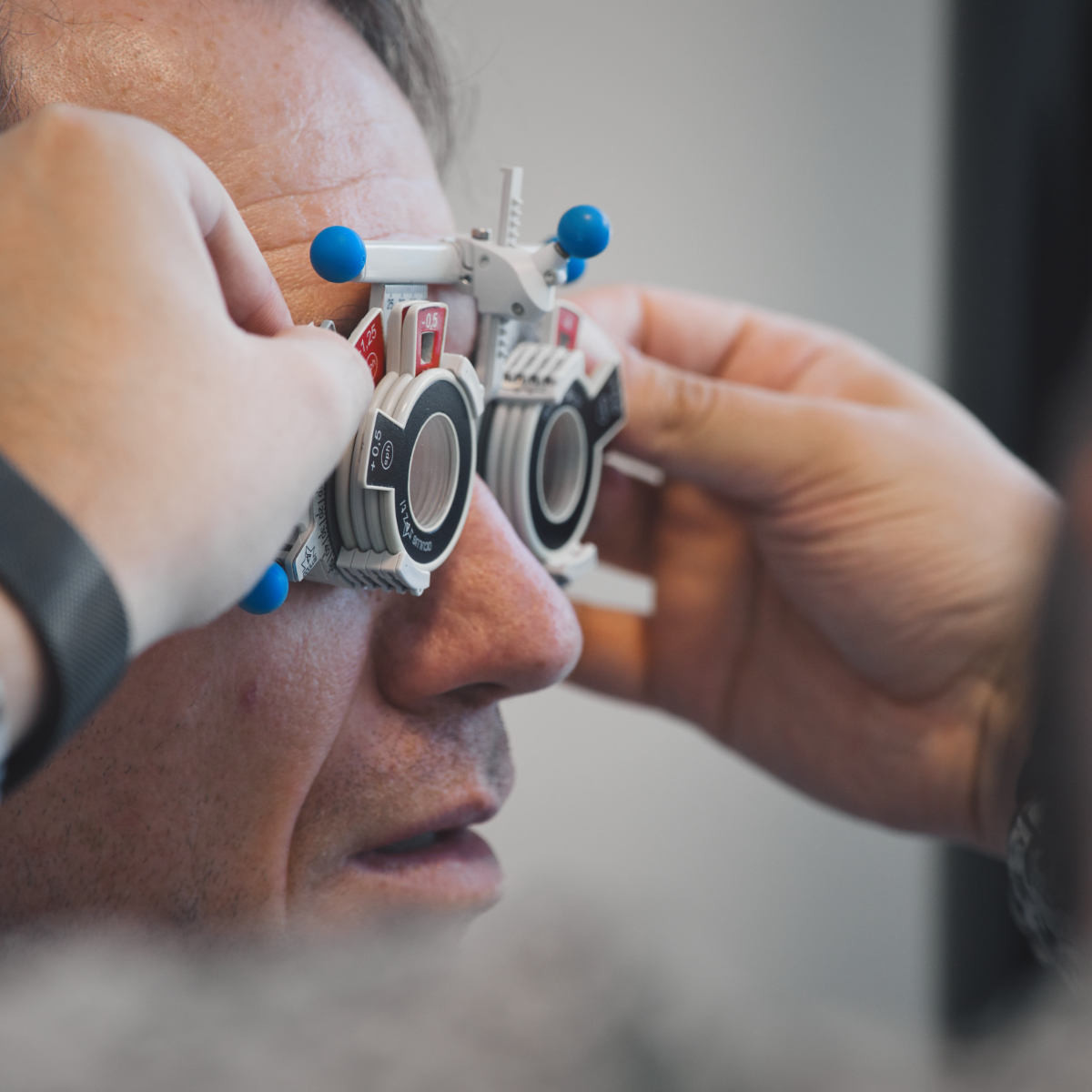 Man having his dioptres measured with a pair of trial glasses - individual lens determination at the optician's.
